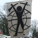 Transparent - Ein Mensch zerbricht ein Gewehr, im Hintergrund stilisierte Weltkugel